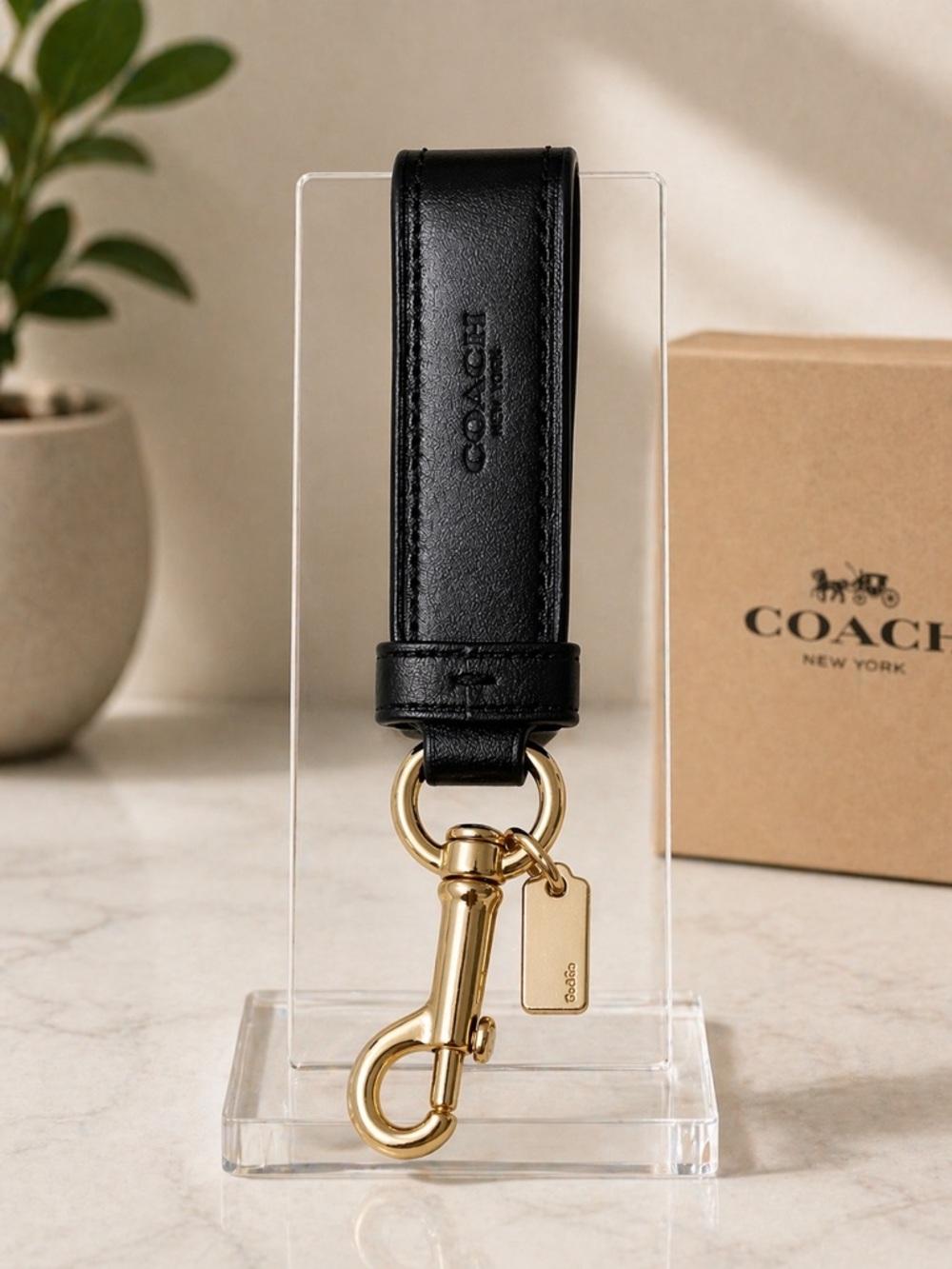 Coach sleek black leather key flob. Polished gold-tone hardware and swivel clasp